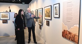 Cristiane Carbone e o des. Encinas Manfré caminham entre as obras da artista no espaço cultural