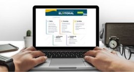 Imagem de uma pessoa acessando a página do Autoatendimento eleitoral com um notebook aberto sobr...