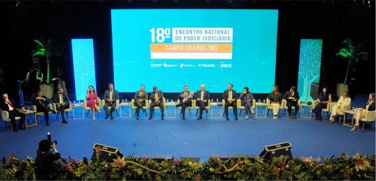 18º Encontro Nacional do Poder Judiciário Foto mostra diversas pessoas sentadas em cadeiras sobre um palco