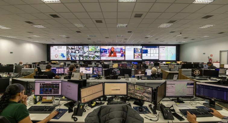 Sala de controle para operações das Eleições 2026, com várias telas e servidores lado a lado em ...