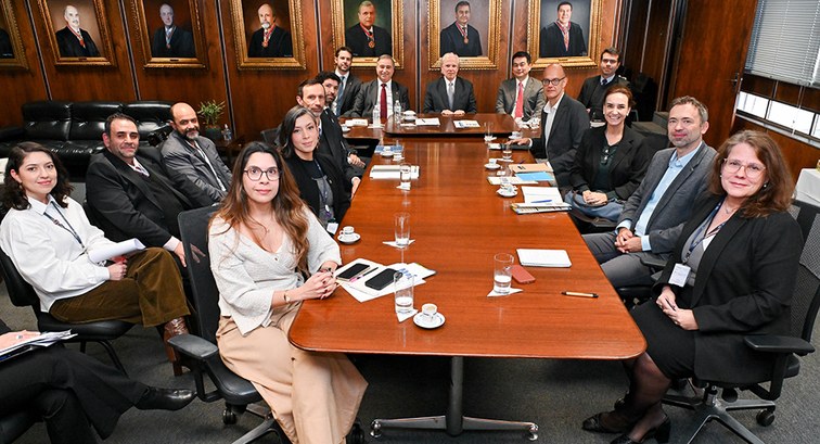 Sala do TRE-SP com paredes de madeira e pinturas de ex-presidentes da Corte Eleitoral. Uma grand...