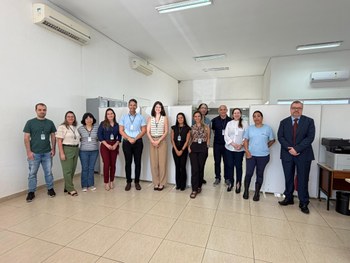 Equipe da Corregedoria e servidoras e servidores de pé diante da sede de cartório eleitoral na r...