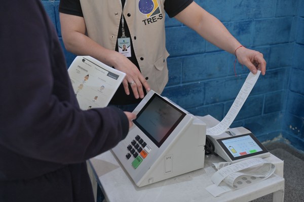 Jovem acompanha votação simulada na urna eletrônica