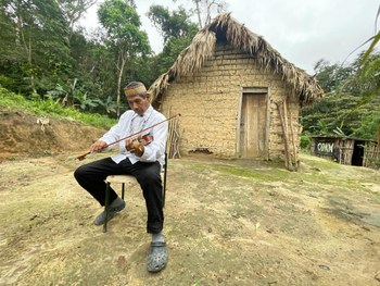 O cacique da aldeia Itapoã, Marcilio da Silva, toca uma música sagrada em frente à casa de reza,...