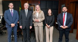 Representantes do TRE-SP e da DPU posam lado a lado para foto na sala da presidência do TRE-SP. ...