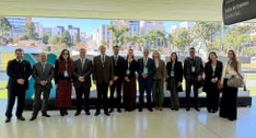 Fotografia colorida, em plano médio e formato horizontal, mostrando um grupo de 13 pessoas (7 ho...