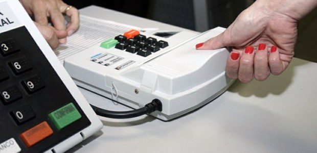 Identificação biométrica sendo coletada de eleitora para votação