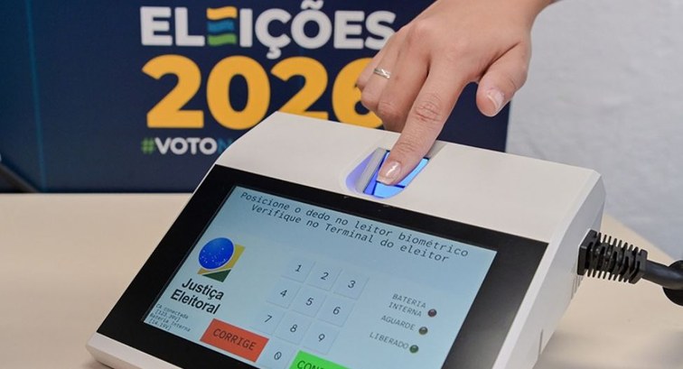 Foto em plano detalhe mostrando a mão de uma pessoa posicionando o indicador sobre o leitor biom...