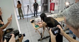 Fotografia que registra o trabalho de preparação de urnas eletrônicas sob o acompanhamento da im...