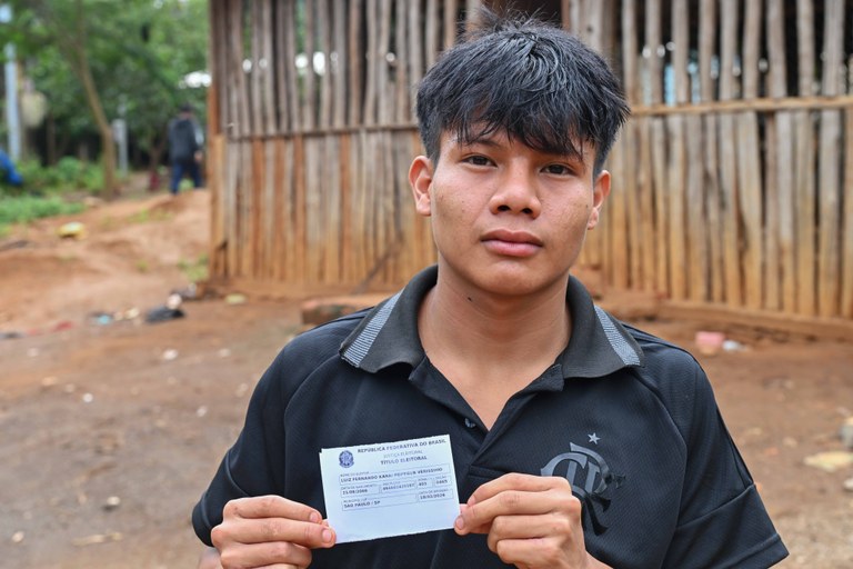Jovem da Terra Indígena Jaraguá com seu titulo de eleitor em mãos