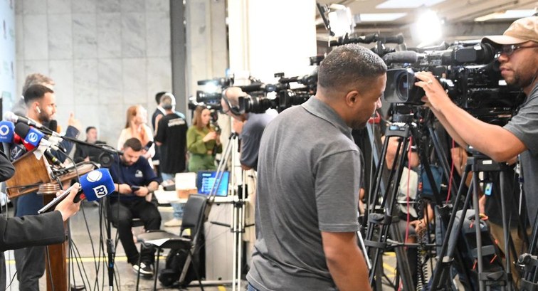 Fotografia na Sala de Imprensa do TRE-SP. Em primeiro plano, à direita, destacam-se dois operado...