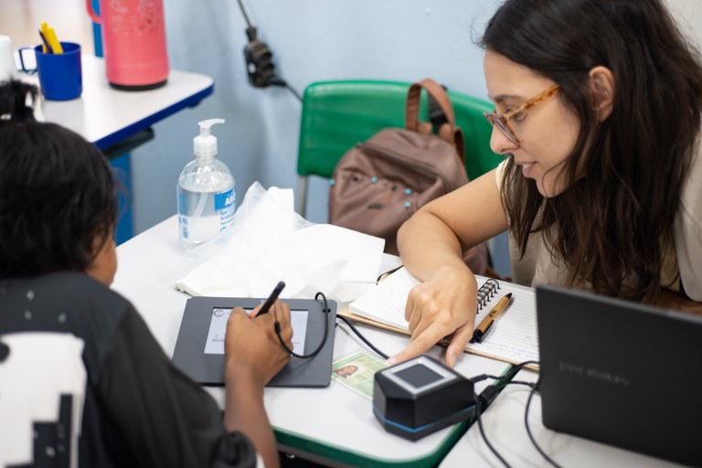 Servidora voluntária Marélen Lopes durante atendimento na comunidade Servidora voluntária Marélen Lopes durante atendimento na comunidade