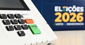 Uma imagem fechada de uma urna eletrônica, em foco, do lado esquerdo da imagem, mostrando os bot...